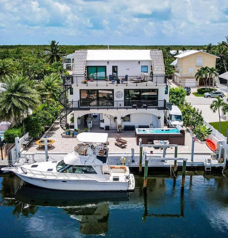 Florida Keys vacation rental with a hot tub, tropical landscaping, and outdoor living space